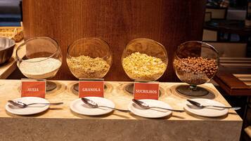 Mostrador de buffet con cuencos etiquetados de diversos alimentos.