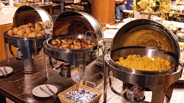 Una mesa de buffet con diferentes tipos de comida y utensilios.