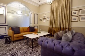 Un salon avec un canapé, une table basse et un tapis à motifs.
