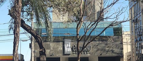 Un immeuble avec une enseigne indiquant « VIA Cortino Hotel » et un parking en dessous.