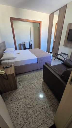 A hotel room with a bed, a desk, a chair, and a television. - Via Contorno Hotel (Belo Horizonte)