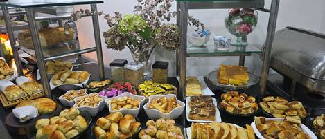 Una mesa de buffet con diferentes alimentos y una planta decorativa.