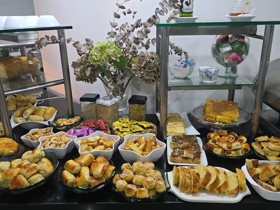 A buffet table with various food items and a decorative plant.