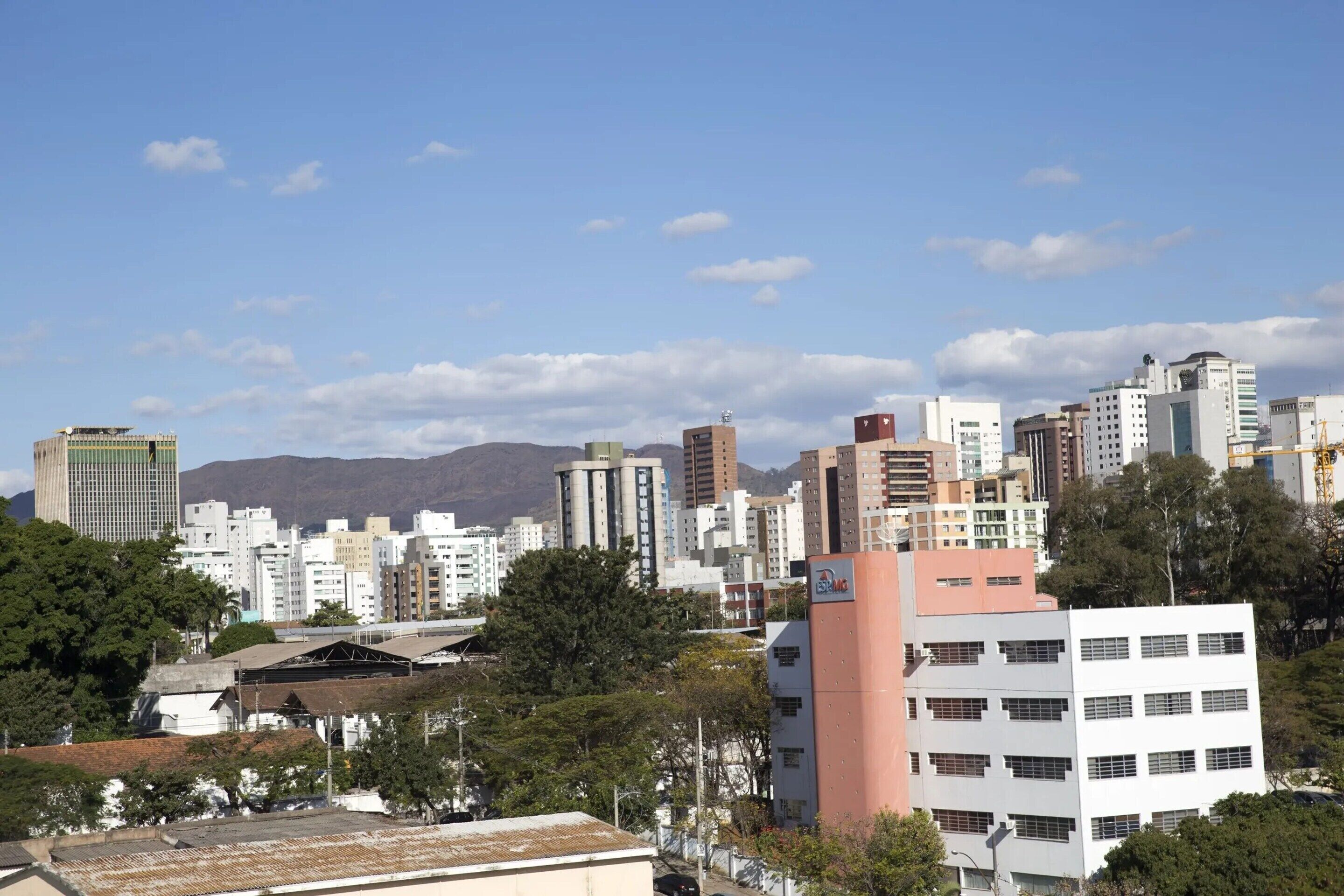 A cityscape with a variety of buildings, including high-rise structures and a prominent pink building in the foreground.
