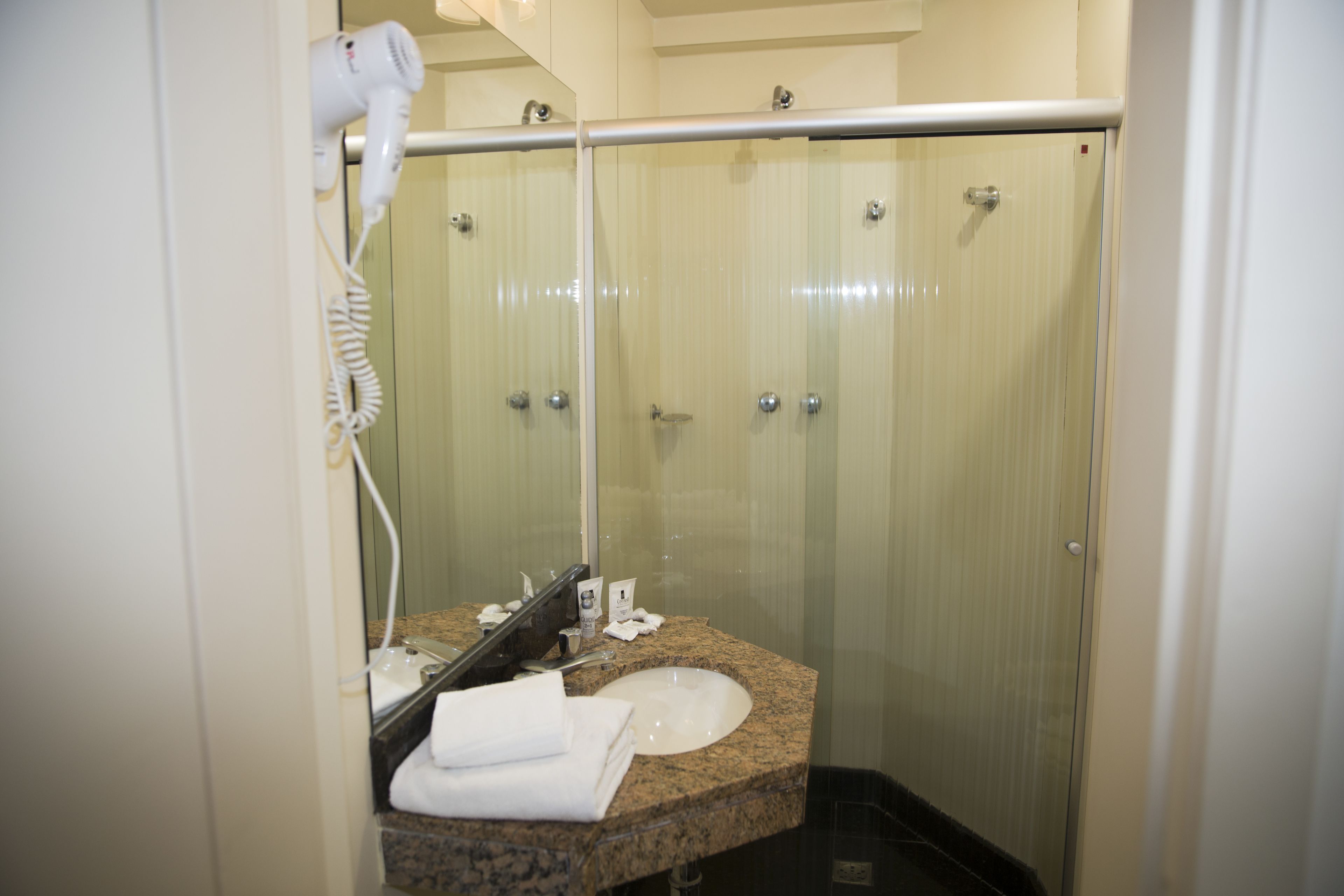 Standaard driepersoonskamer | Badkamer | Een douche, gratis toiletartikelen, een haardroger, handdoeken