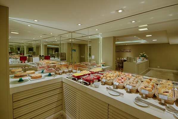 A buffet with various food items and a mirror reflecting the room.