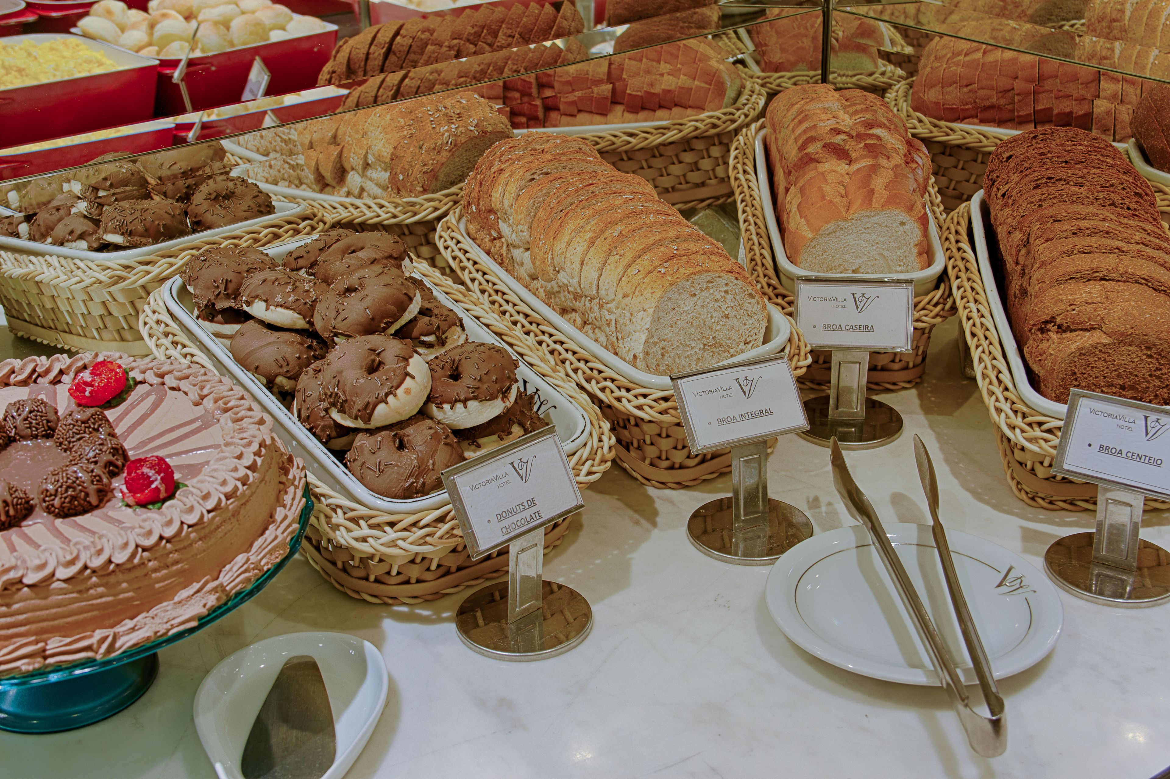 Una vitrina de panadería con diferentes panes y pasteles.