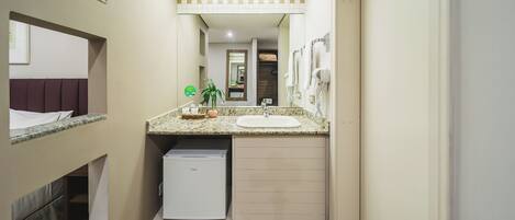 A narrow hallway with a small kitchenette area, a sink, and a compact refrigerator.