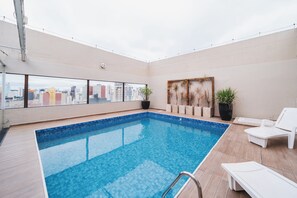 A rooftop swimming pool with a city view, lounge chairs, and potted plants. - Hotel Victoria Villa Curitiba By Nacional Inn (Curitiba)