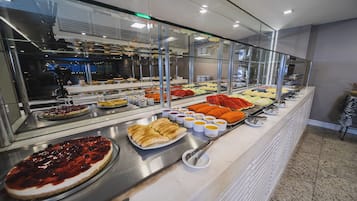 Buffet com diversos alimentos e uma vitrine de vidro.