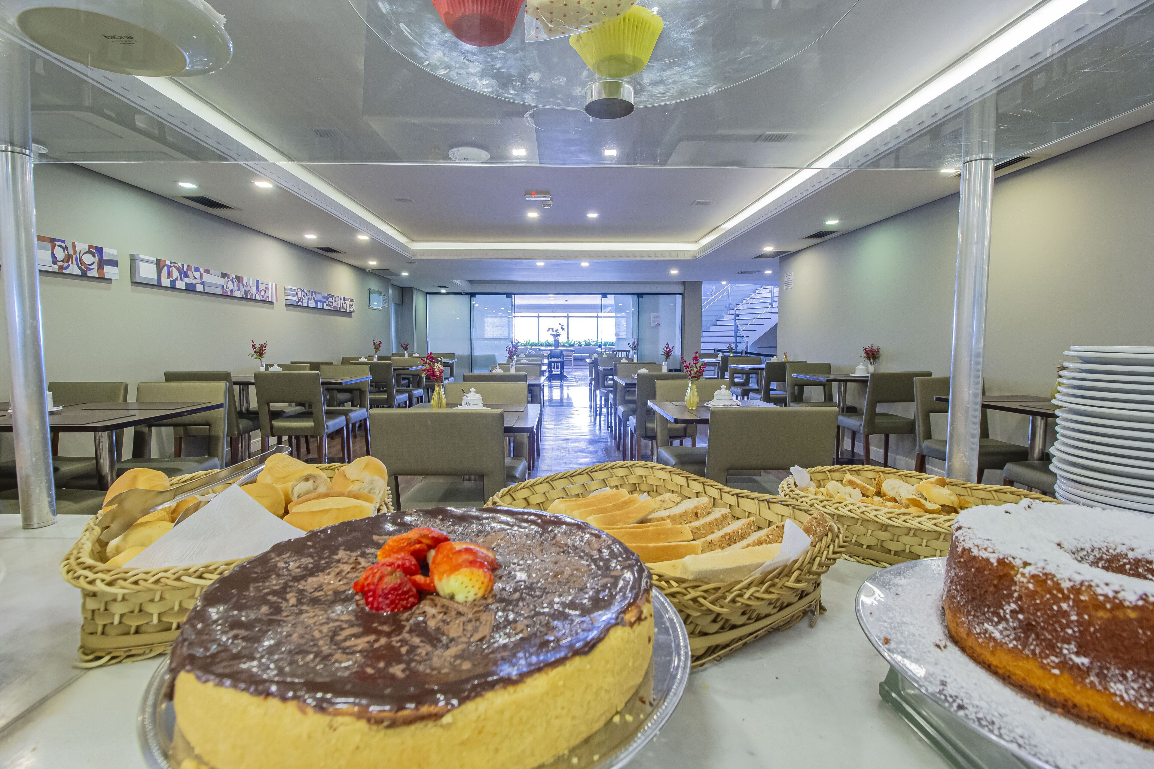 A buffet area with various desserts and bread baskets.