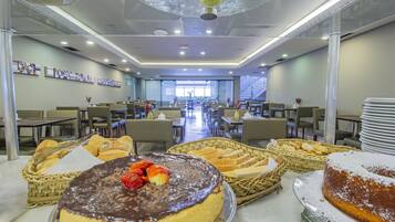 A buffet area with various desserts and bread baskets.