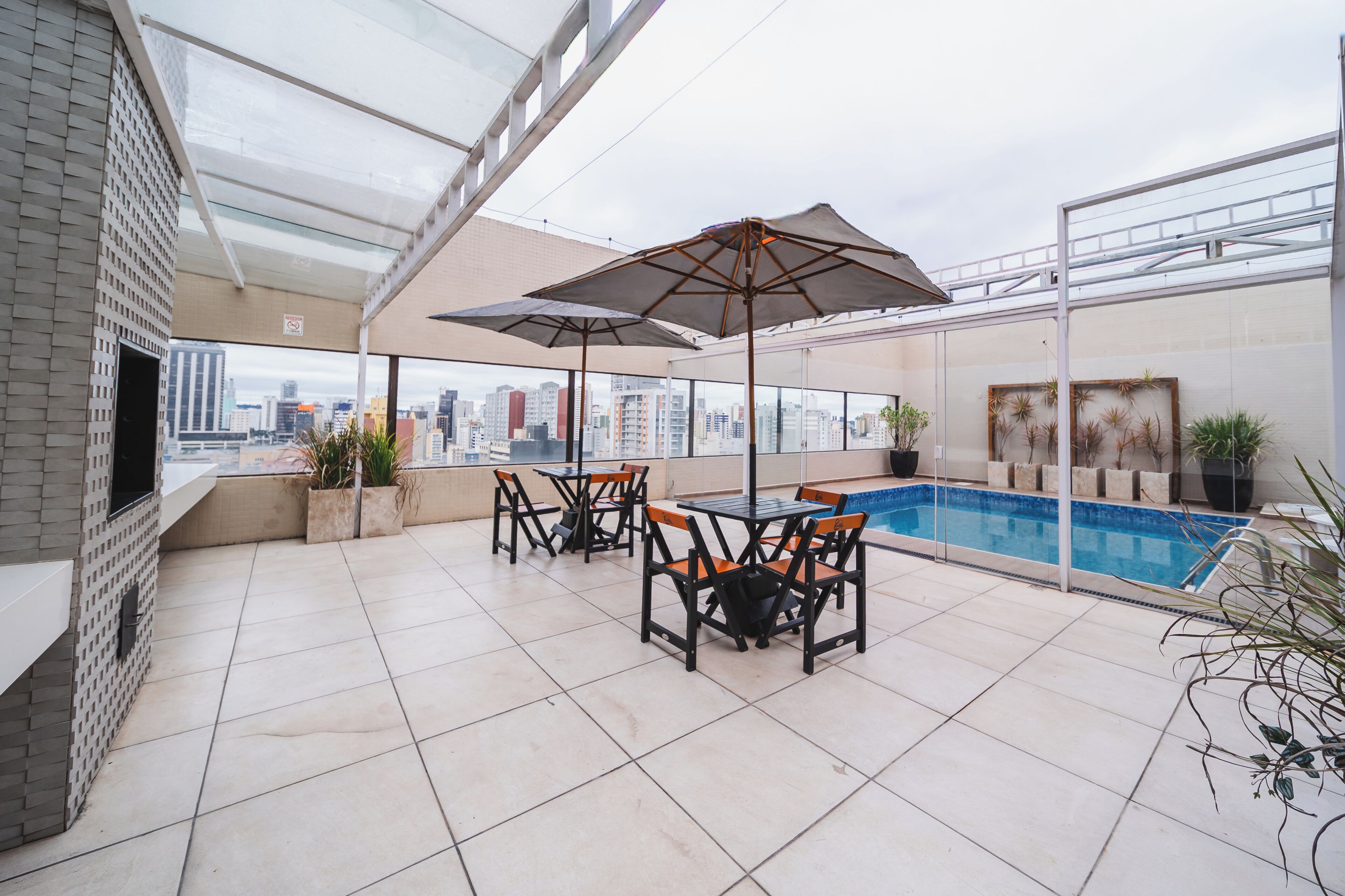 Terraço no telhado com piscina, área de estar ao ar livre e vista para a cidade.