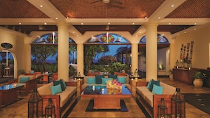 A spacious lobby with comfortable seating, a central coffee table, and decorative lanterns.
