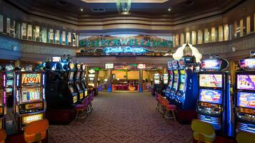 Un casino con múltiples máquinas tragamonedas y un letrero de neón que dice 'Desert Jewel Casino Double Diamonds'.