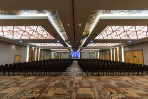 A conference room with rows of chairs, a patterned carpet, and a geometric ceiling design. - Windhoek Country Club (Windhoek)