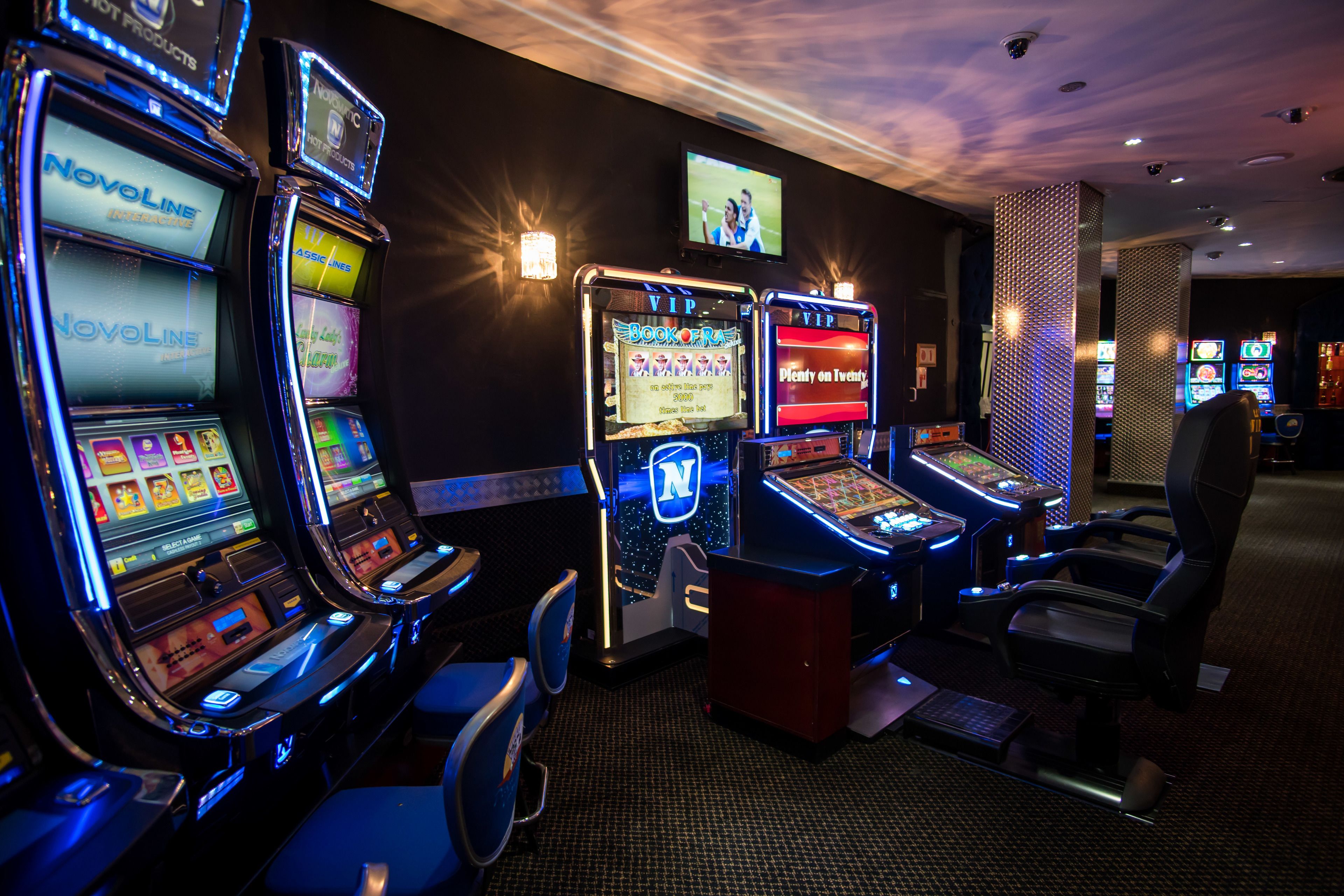 A row of slot machines with a 'Book of Fire' game, a 'N' logo, and a 'Deny on Twenty' game.