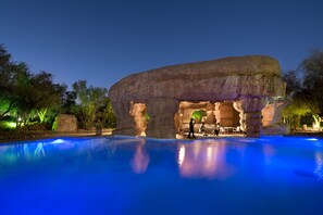 Una piscina al aire libre, sombrillas, sillones reclinables de piscina