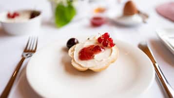 Ein Dessert auf einem weißen Teller mit Gabel und Messer daneben.