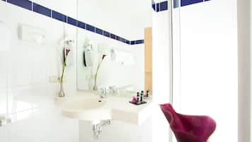 Ein modernes Badezimmer mit Waschbecken, Spiegel und Handtuchhalter.