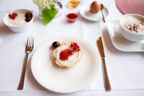 A white table with a plate of food, a fork, a knife, and a cup of coffee. - elaya hotel wolfenbuettel, Trademark Collection by Wyndham (Wolfenbuettel)