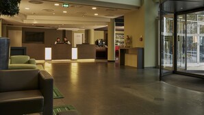A spacious lobby with a reception desk, seating area, and a bar. - Sunday Hotel Kassel (Kassel)