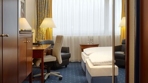 A hotel room with a bed, desk, chair, and two lamps. - Sunday Hotel Kassel (Kassel)