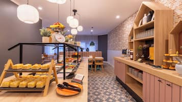 Un ricco buffet per la colazione con diverse pietanze e un angolo caffè.