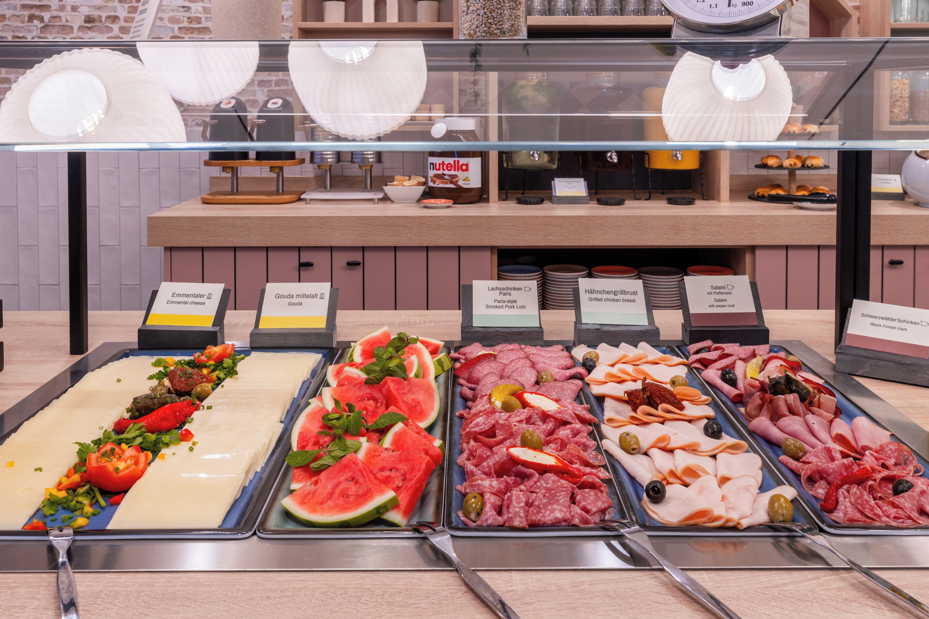 Un comptoir de charcuterie proposant divers assortiments de viandes et de fromages, notamment du salami, du jambon et de la mozzarella.