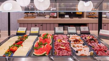 Un comptoir de charcuterie proposant divers assortiments de viandes et de fromages, notamment du salami, du jambon et de la mozzarella.