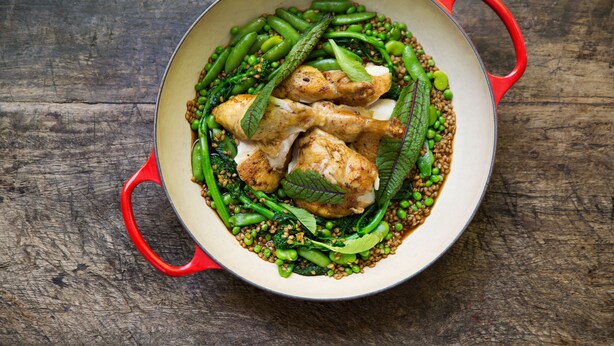 A bowl of food with green vegetables and chicken on a wooden surface. - Harvest Inn (St. Helena)
