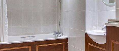 Un baño moderno con cabina de ducha, tocador de madera y retrete.