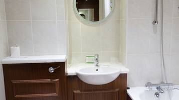 Une salle de bain équipée de toilettes, d’un lavabo, d’un miroir et d’une douche.