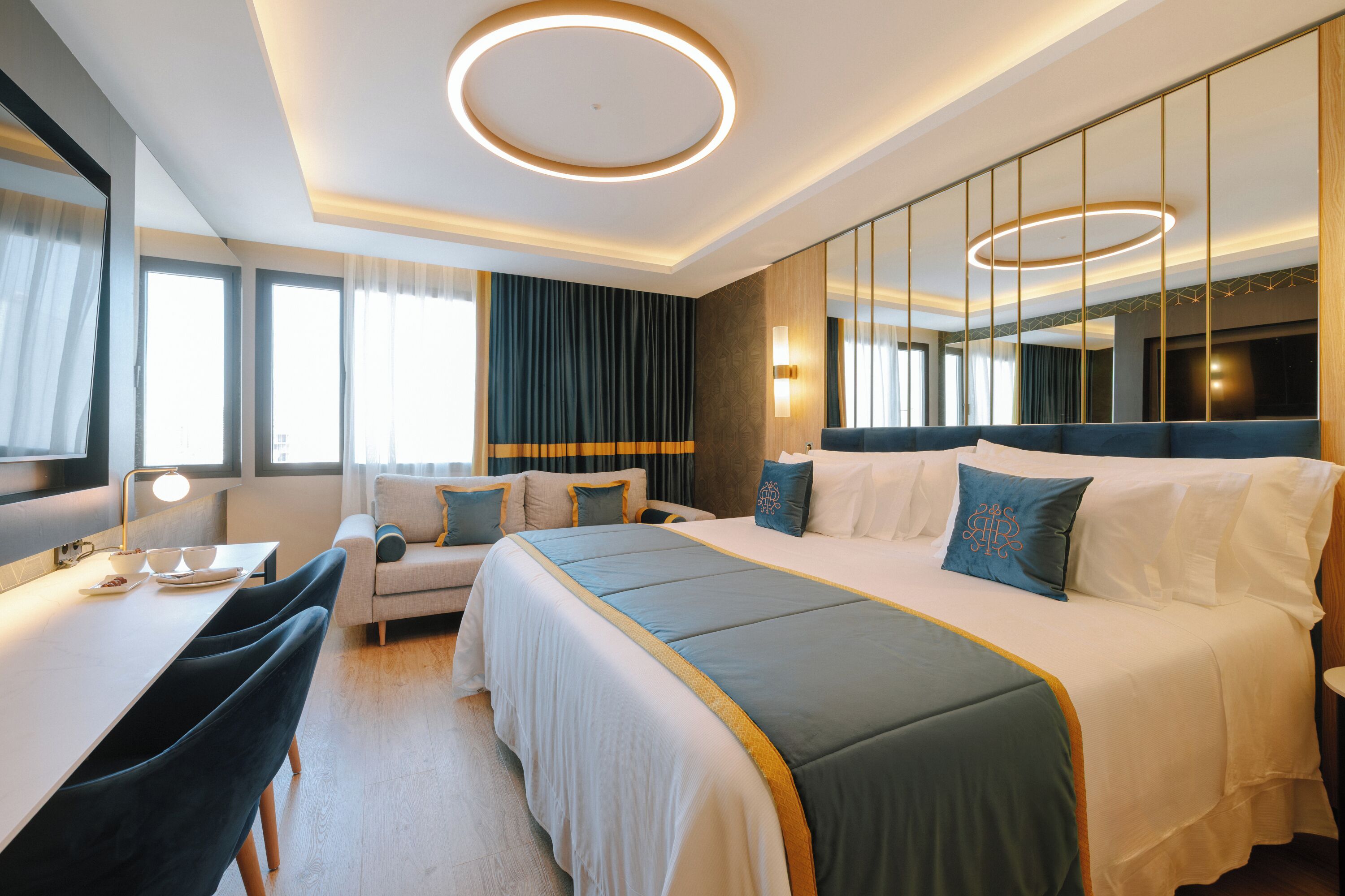 Une chambre d’hôtel moderne avec un grand lit, un bureau et un miroir.