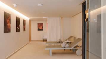 A modern spa room with a bench, a chair, and a small table with a glass.