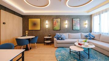 A modern living room with a sofa, two round tables, and a blue rug.