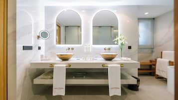 Un baño moderno con dos lavamanos, espejos grandes y un mueble de tocador con toallas.