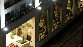 Un hotel moderno a più piani, con balconi, ampie finestre e un atrio centrale con zone salotto.