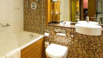 A modern bathroom with a bathtub, toilet, and sink.