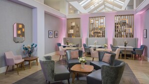Een moderne zithoek met zithoekopstellingen, tafels en decoratieve elementen.