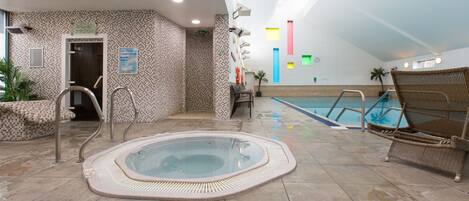A hot tub, lounge chairs, and a pool in a hotel.