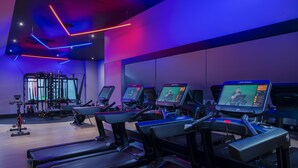 Een sportschool met loopbanden, spinningfietsen en krachtapparaten.