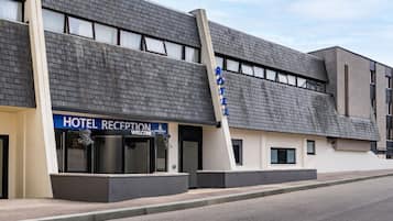 A hotel reception with a modern design, featuring a flat roof and large windows.
