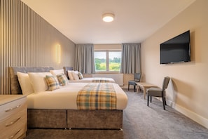 A hotel room with a large bed, a desk, a chair, a television, and a window with curtains. - Britannia Aberdeen Hotel (Aberdeen)