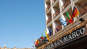 A hotel with multiple balconies and flags, including the flag of San Marino. - Hotel Excelsior San Marco (Bergamo)