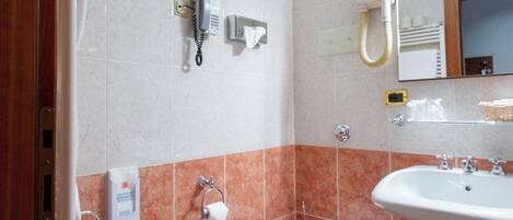 A bathroom with a bidet, toilet, and sink.
