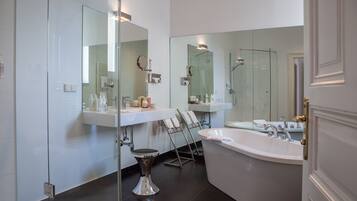 Un baño moderno con cabina de ducha de vidrio, una bañera independiente y un tocador con espejo.