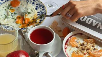 Una mesa de comedor con un plato de comida, una copa de vino, una taza de té y diferentes condimentos.