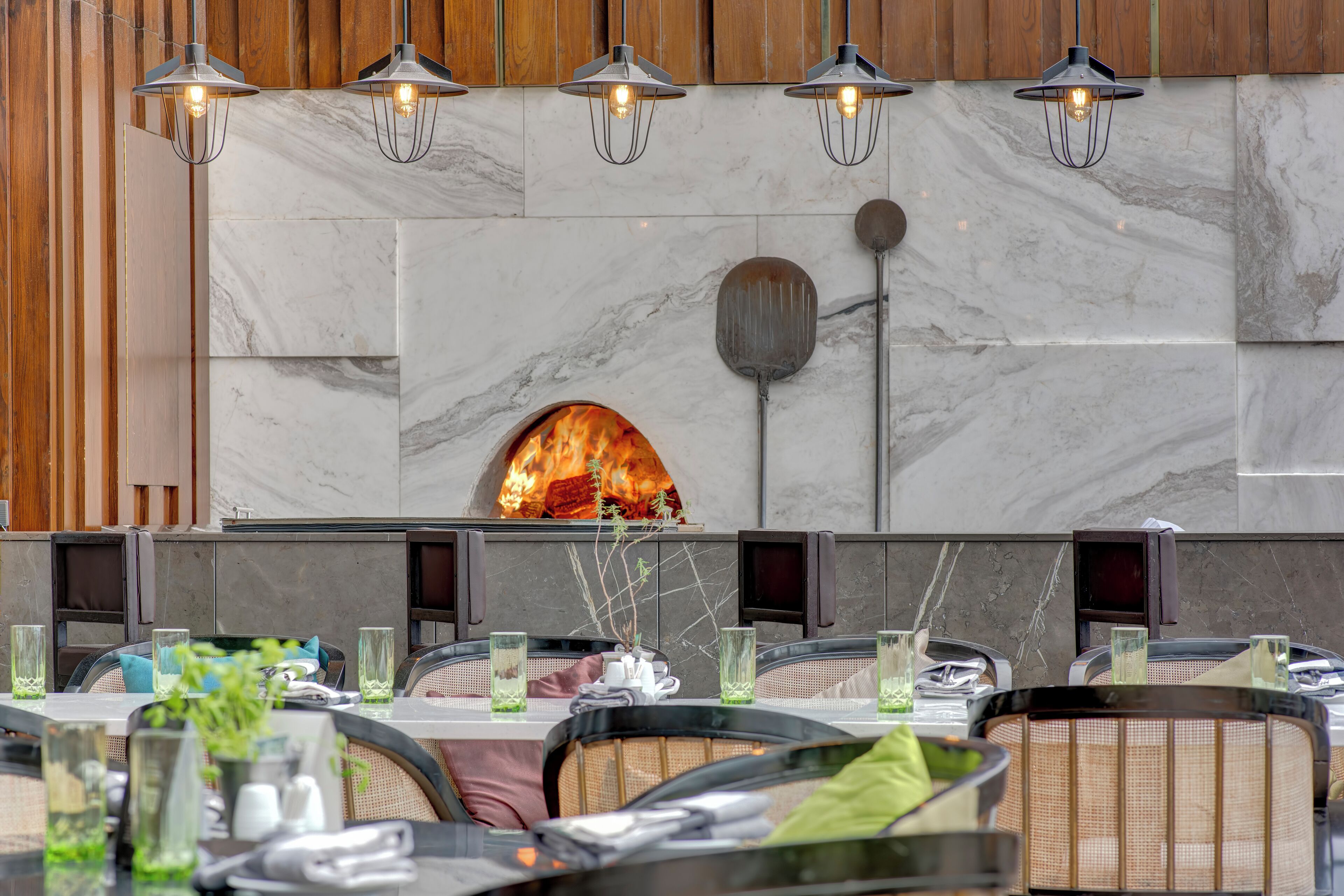 Un ristorante con parete in pietra, camino e luci a sospensione.