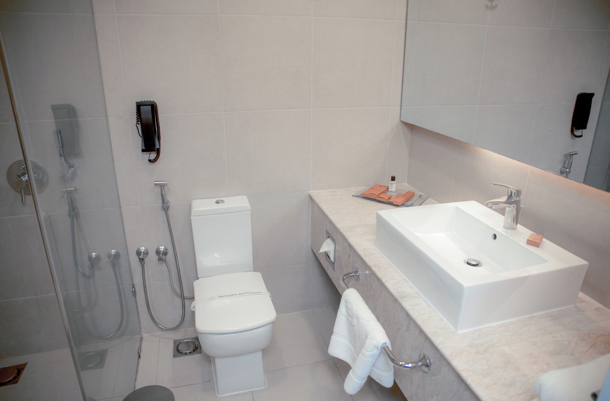 A modern bathroom with a toilet, shower, and sink.